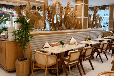 Rattan chairs and stone topped tables among dried grasses at City Centre Bahrain