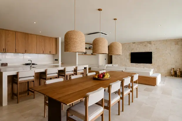 A timber dining table and chairs under woven pendants in the open plan living space at Villa Marena